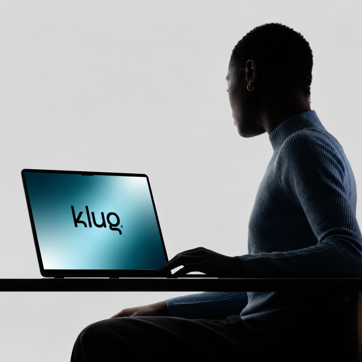 Persona trabajando en una notebook con el logo de Klug en pantalla